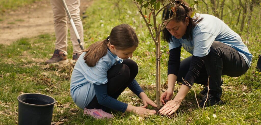 A woman and a child planting a grapevine.